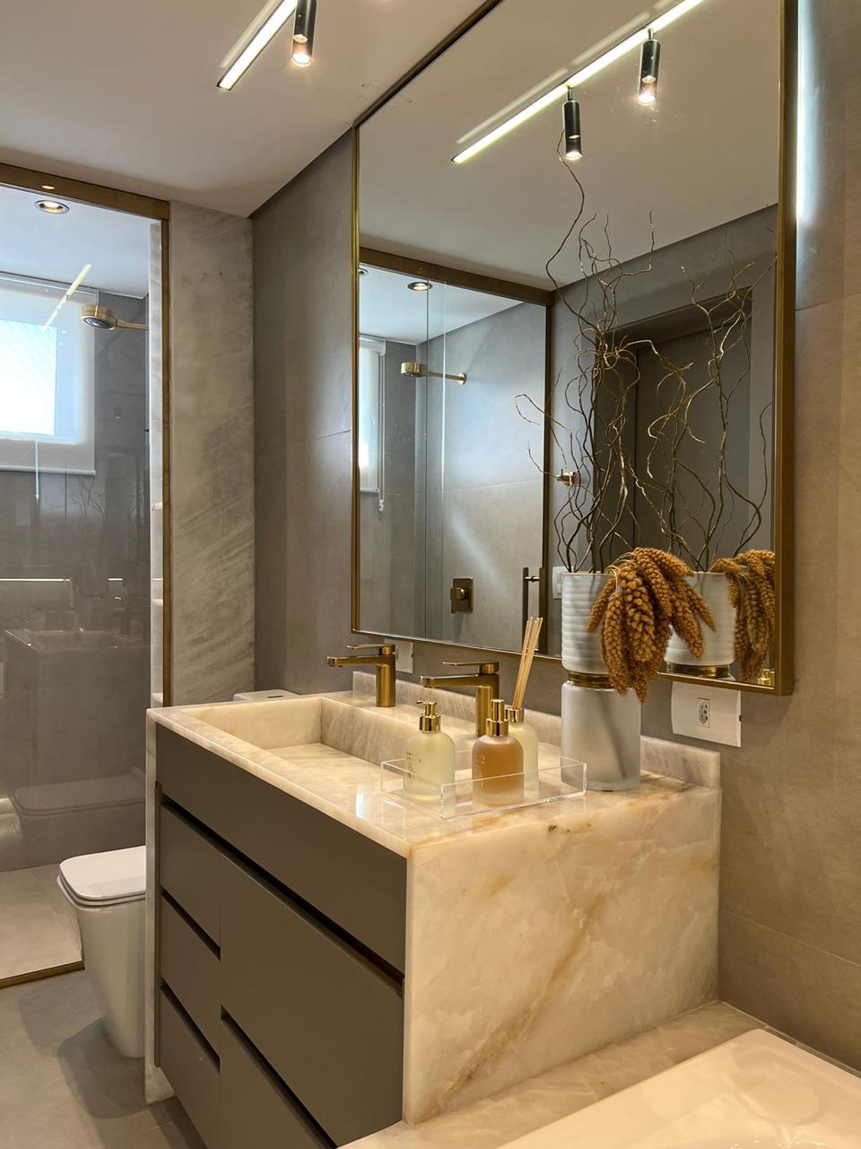 Banheiro de suíte com bancada em mármore e box do apartamento Park Tower à venda em Maringá