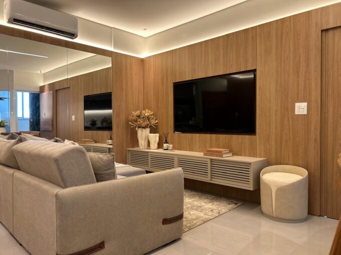 Sala de estar com painel de madeira e TV do apartamento 77 m² à venda no Villagio di Itália, Maringá