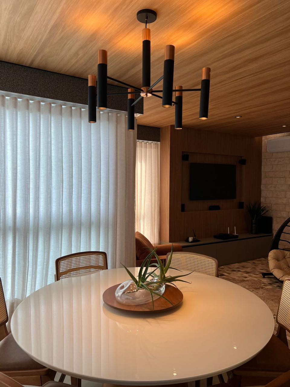 Sala de jantar mobiliada com lustre e cortinas do apartamento Park Tower à venda em Maringá